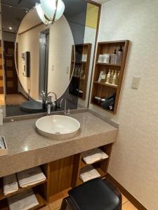 a bathroom with a sink and a mirror at ホテルロアール 大人専用 in Miyake