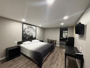 a bedroom with a bed and a desk and a television at Super 8 by Wyndham Visalia in Visalia