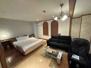 a bedroom with a bed and a couch at ホテルロアール 大人専用 in Miyake