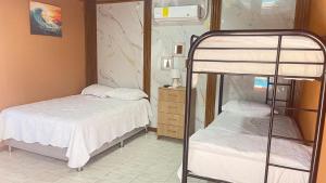a bedroom with two beds and a bunk bed at Macaws Villa in Ciudad Cortés
