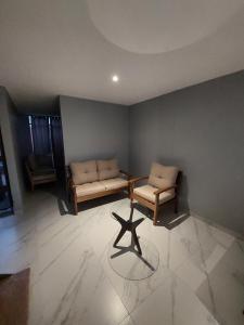 a living room with two chairs and a table at Casa De La Suerte in Chapulco