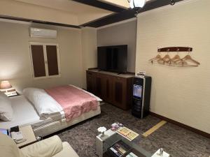 a hotel room with a bed and a flat screen tv at ホテルロアール 大人専用 in Miyake