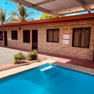 a swimming pool in front of a building at Macaws Villa in Ciudad Cortés