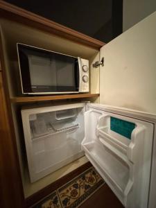 an open refrigerator with a microwave on top of it at ホテルロアール 大人専用 in Miyake