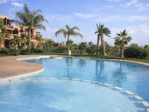 a large swimming pool with palm trees in the background at Stylish Apartment with Pool in Marrakech in Marrakesh