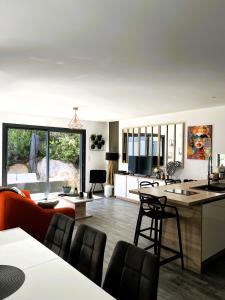 a kitchen and living room with a table and chairs at Villa l'Immortelle in Zonza