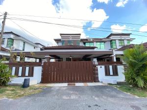a house with a wooden gate and a fence at Ruma Relaxz by Jeffery Lam Home Management in Malacca