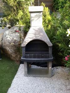 a stone oven sitting on a pile of gravel at Villa l'Immortelle in Zonza