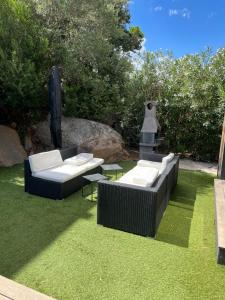 two couches and chairs on the grass in a yard at Villa l'Immortelle in Zonza