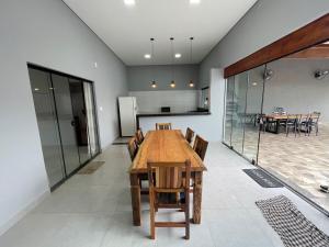 a kitchen and dining room with a wooden table and chairs at Casa de lazer privativa in Barretos