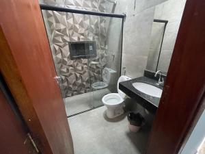 a bathroom with a shower and a toilet and a sink at Casa de lazer privativa in Barretos