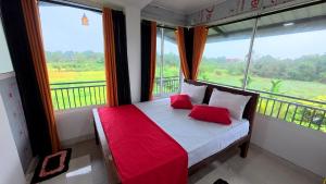 a bed with red pillows in a room with windows at Meegahapokuna Resort in Anuradhapura +174 photos