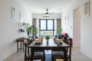 a living room with a table and chairs and a couch at Meritus Suites - 8pax in Perai