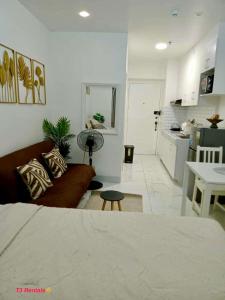 a living room with a couch and a kitchen at CASA DOBLE DOSE Condo in Victoria Sports Complex EDSA near GMA Kamuning QC in Manila