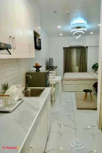 a kitchen with a sink and a room with a bed at CASA DOBLE DOSE Condo in Victoria Sports Complex EDSA near GMA Kamuning QC in Manila +10 photos