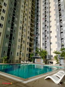 a swimming pool in front of two large buildings at CASA DOBLE DOSE Condo in Victoria Sports Complex EDSA near GMA Kamuning QC in Manila