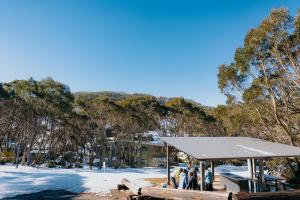 a group of people standing under a pavilion in the snow at Altitude Apartment 1 in Baw Baw Village