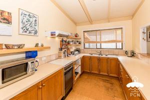 a large kitchen with wooden cabinets and a window at Dune Cottage Stay 3 Pay 2 Winter Special in Sandy Point +5 photos