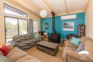a living room with two couches and a wood stove at Dune Cottage Stay 3 Pay 2 Winter Special in Sandy Point