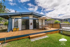 a deck with a picnic table and an umbrella at Dune Cottage Stay 3 Pay 2 Winter Special in Sandy Point