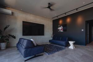 a living room with two blue couches and a flat screen tv at Luxury Villa Maeda Unit2 in Onna