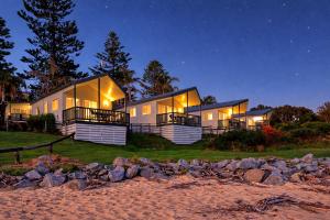 a house on the beach at night at Tuross Beach Cabins & Campsites in Tuross Heads