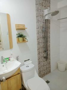 a bathroom with a toilet and a sink and a shower at CASA DOBLE DOSE Condo in Victoria Sports Complex EDSA near GMA Kamuning QC in Manila