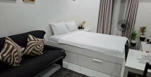 a small bedroom with a bed and a couch at CASA DOBLE DOSE Condo in Victoria Sports Complex EDSA near GMA Kamuning QC in Manila