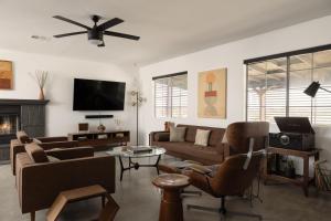 a living room with a couch and a tv at Dark Star - Endless Stars, Cowboy Pool, Spa, Fire pit, BBQ in Twentynine Palms