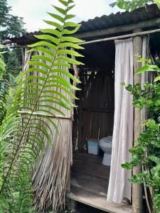 a bathroom with a toilet and a palm tree at Hostal Posada Turística El Bejuco in Leticia