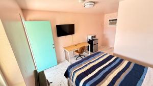 a bedroom with a bed and a desk with a television at El Rey Motel in Globe +14 photos