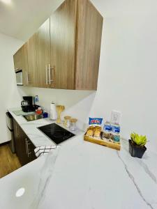 a kitchen with white counter tops and wooden cabinets at Apartaments in Sandy Bay in Sandy Bay