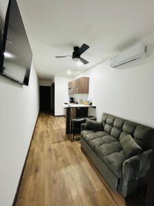 a living room with a couch and a kitchen at Apartaments in Sandy Bay in Sandy Bay