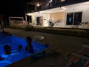 two children sitting in a swimming pool at night at Corazón zen in Barra de Potosi +14 photos