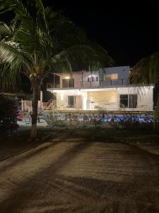 a house with a palm tree in front of a building at Corazón zen in Barra de Potosi