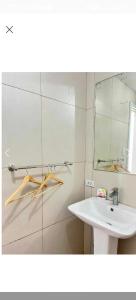 a white bathroom with a sink and a mirror at Condotel in Baguio City in Baguio +11 photos