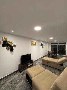 a living room with a couch and a flat screen tv at Alma del Mar in Volcán Chimborazo