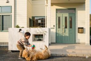 a young boy playing with two dogs with a ball at koyado kaziya in Ichinoseki