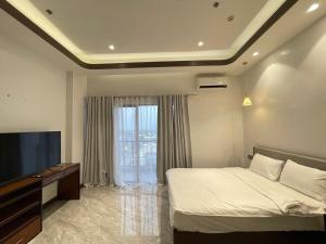 a bedroom with a bed and a flat screen tv at Viewtiful Elegant 16th Floor 1BR Getaway 1Euphoria in Angeles