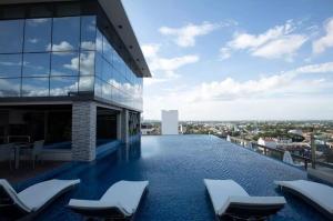 a swimming pool on the roof of a building with chairs at Viewtiful Elegant 16th Floor 1BR Getaway 1Euphoria in Angeles
