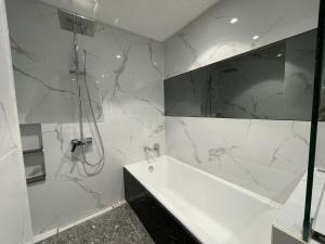 a bathroom with a shower and a tub and a sink at Viewtiful Elegant 16th Floor 1BR Getaway 1Euphoria in Angeles +16 photos