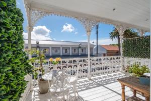 a white porch with a white fence and a table at The Willets Boutique Hotel in Simonʼs Town