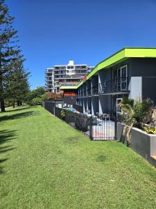 a building with a grass yard next to a building at Le George Motel in Port Macquarie
