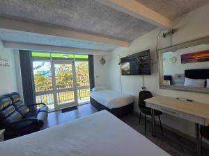 a hotel room with a bedroom with a bed and a desk at Le George Motel in Port Macquarie