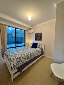a bedroom with a bed and a large window at Wandju Villa in Geographe