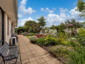 a patio with a bench and a garden at Wandju Villa in Geographe