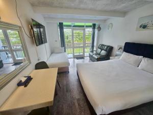 a bedroom with a bed and a desk and a chair at Le George Motel in Port Macquarie +65 photos