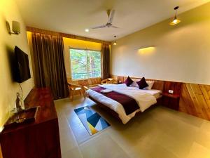 a bedroom with a bed and a table and a television at Cedar wave in Munsyari