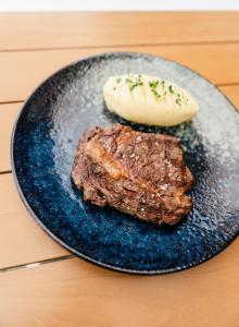 a steak on a black plate with a treat at Tocumwal Hotel Motel in Tocumwal