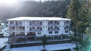 an apartment building with snow on the ground at Cedar wave in Munsyari